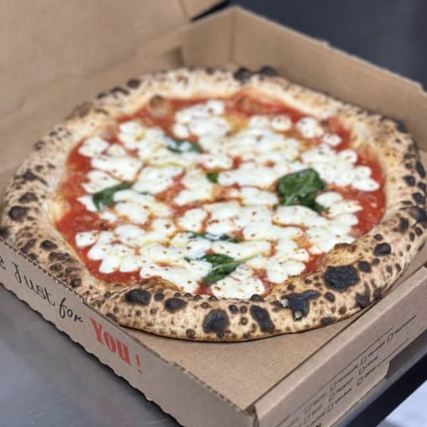 A BareBakedPizza Margherita pizza with fresh mozzarella and basil in a cardboard box.